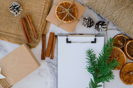 Woman preparing for christmas holidays. Writing gift list. Box with New Year's gifts, wrapped in...