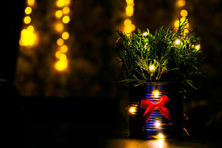 Christmas decorated eco christmas tree in metal jar with bokeh lights on background in living room...