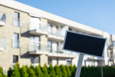 Blank Black billboard against new apartment building Empty mockup template Blackboard label Home for...