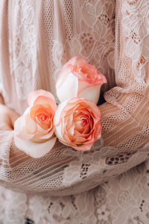 Female hand in pink blouse holding tender pink rose. Minimal trendy composition. Abstract art idea. Romantic pastel pink rose flower. Modern aesthetic. Neutral earth tones. Creative Greeting card background Verticalの写真素材