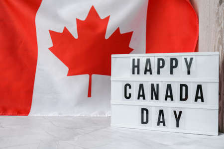 The National Flag of Canada. Lightbox with text HAPPY CANADA DAY Canadian Flag or the Maple Leaf. Patriotism. International relations concept. Independence day. Immigrationの写真素材