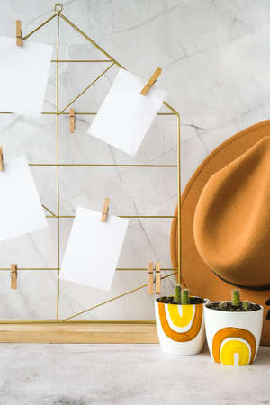 Cards and posters mock ups on grid board. Copy space. Feminine hipster office table decoration. Home office desktop. Freelance bloggers workplace. Cowboy hat decorの写真素材