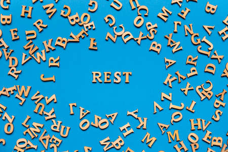 Word REST made out of wooden letters on bright blue background. Motivational Words Quotes Concept. Inspirational phraseの写真素材