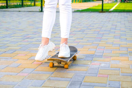 Close up Girl skateboarder legs skateboarding at sunset. sun backlight and freedom rebel independent...