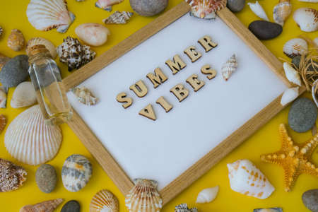 Composition sheet white paper text SUMMER VIBES, seashells, pebbles, mockup on yellow background. Blank, top view, still life, flat lay. sea vacation travel concept tourism and resorts. summer holidaysの写真素材