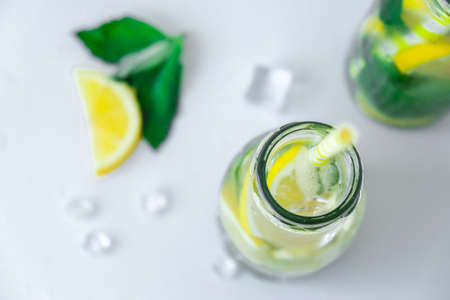 Mojito refreshing cocktail with eco paper drinking straw, alcohol drink. Lemonade with lemon and...