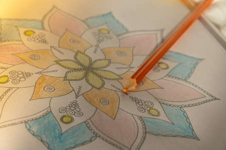Mandalas antistress page to combat stress. Relaxing hobby mental wellbeing and art therapy. Meditative process of coloring pages. Self expression by artの写真素材