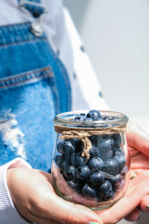 Woman holding bowl with fresh blueberries. harvesting concept. Female hands collecting berries. The concept of vegetable garden cottage harvest gardening. healthy eating nutritionの写真素材