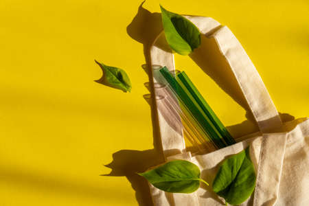 Reusable glass Straws on colorful background with green leafs in eco bag Eco-Friendly Drinking Straw Set Reusable Comfortable Rounded tip Drinking Straw. Zero waste, plastic free concept. Sustainable lifestyle. Picnic conceptの写真素材