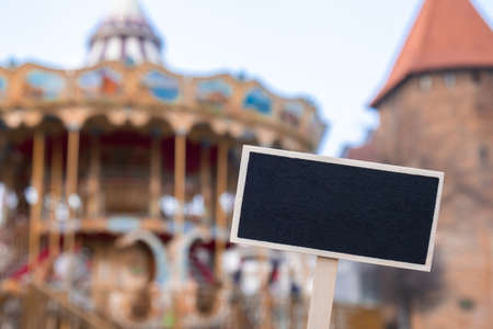 Empty mockup template Blackboard label against Carousel in amusement park. Old-fashioned merry-go-round carousel Colorful carnival Horses Travel atractionsの写真素材