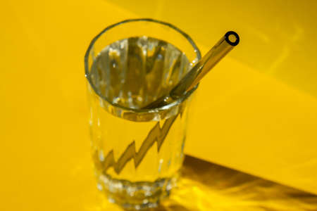 Reusable glass Straws in Glass with water on yellow background Eco-Friendly Drinking Straw Set with cleaning brush. Zero waste, plastic free conceptの写真素材
