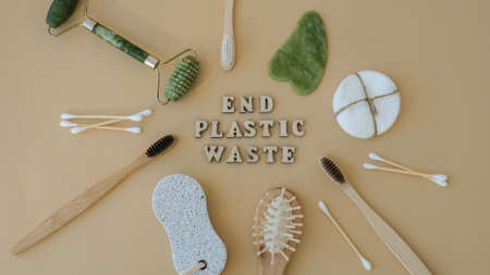 END PLASTIC WASTE text around Natural skin care products on neutral beige background, flat lay....