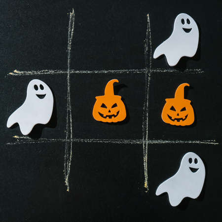 Creative tic tac toe game made of halloween decorations. Ghost bat pumpkin Autumn party concept Craft diy children gameの写真素材