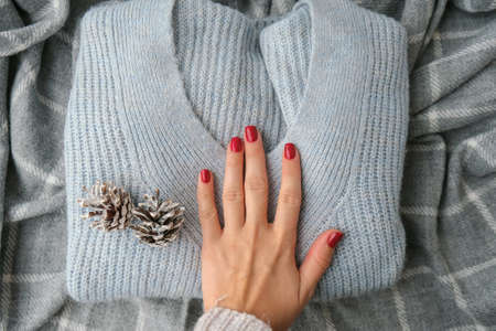 Woman manicured hands, stylish red nails, copy space. Blue sweater Closeup. Winter or autumn style of nail design concept. beauty treatment. Fall nailsの写真素材