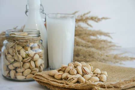 Glass of healthy pistachio milk stands on concrete background. Diet milk, vegetarian food. Gluten free. Close-up. Pistachio lactose free milk for dietary nutrition. Alternative food and vegetarianism. Nut non-dairy milkの写真素材