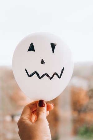 Painted Jacks face on balloons. Orange and white balls preparation diy for halloween party. Halloween home activities. Handmade toysの写真素材