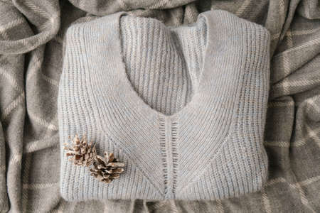 Blue sweater with white pine cones. Cozy winter background. Scarf knitted sweater backdrop Copy...