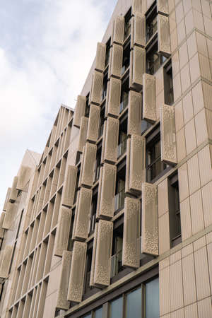 Modern office building exterior with glass facade on clear sky background. Transparent glass wall of...