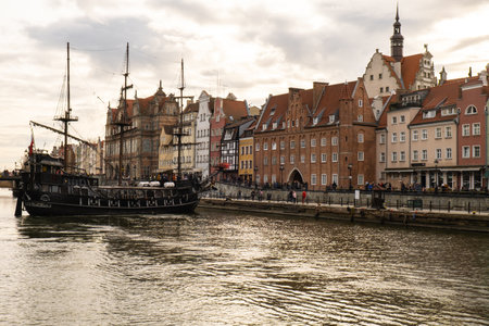 Beautiful old town of Gdansk over Motlawa river Vintage ship pirate caravels sailing on Motlawa river with historic port Crane in Old Town on background. Gdansk, Poland. This ship imitating XVII century galleon is big tourist attraction of Tri city in Poland. Travel destinationの写真素材