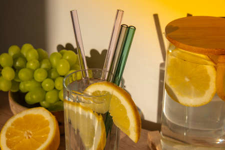 Glass of water with fresh lemon juice with Reusable glass Straws Detox cold tonic water with sunny lemon slices Low-waste lifestyle Eco-Friendly Drinking Straw Set with cleaning brush. Zero waste, plastic free conceptの写真素材