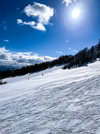 Skiers skiing downhill in winter resort mountains. Skiers and snowboarders riding down the hill....