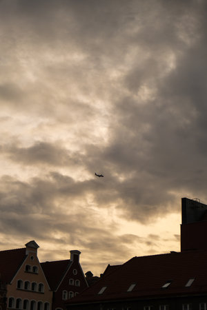 Airplane Landing Gdansk over Old town. Tourist attraction, travel destination Moody sky