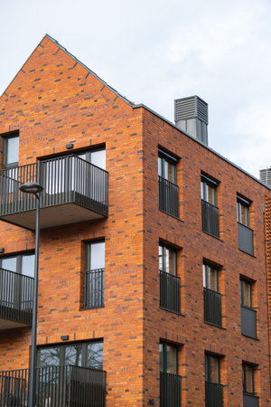 Modern office building exterior with glass facade on clear sky background. Transparent glass wall of office building with reflection of clouds. Element of facade of modern European building Commercial office buildings. Abstract modern business architectureの写真素材
