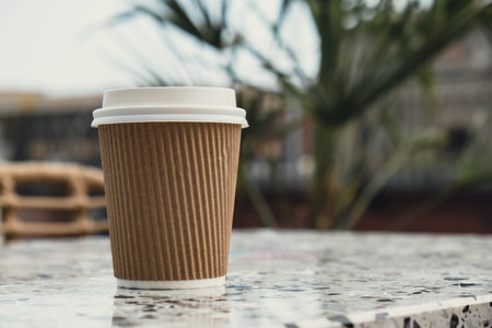 Eco recycling paper cup with coffee or tea on craft paper on table in beach cafe. Take away coffee to go. Copy space for text. Disposableの写真素材