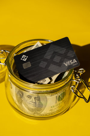 Gdansk Poland - 20 June 2022: Black Binance Coin Card with dollars. Visa debit card BNB, Binance Exchange Cryptocurrency Card to buy bitcoin. Crypto exchange during the market crash. Blockchain cryptocurrency payment solution Digital currency moneyのeditorial素材