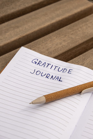Writing Gratitude Journal on wooden bench. Today I am grateful for. Self discovery journal, self reflection creative writing, self growth personal development concept. Self care wellbeing spiritual health, being mindful, holistic health practices habits mindfulnessの写真素材
