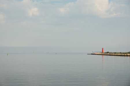 Lighthouse on blue sea line. Waves on sunny day on Baltic sea. Gdansk Poland. Swimming by ship to...
