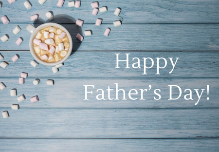 HAPPY FATHERS DAY text Greeting card with white cup of coffee and marshmallows on wooden blue background. Design wallpaper holidayの写真素材