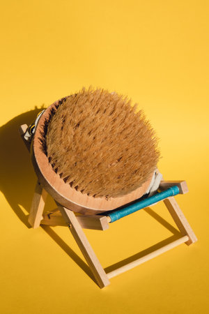 Dry massage brush on beach chair with natural bristle, ecological cosmetics, home care. Bamboo Brush for dry anti-cellulite massage. Spa beauty conceptの写真素材