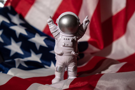 Plastic toy figure astronaut on American flag background Copy space. 50th Anniversary of USA Landing...