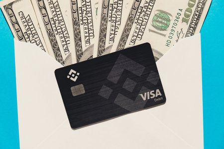 Gdansk Poland - 20 June 2022: Black Binance Coin Card with dollars. Visa debit card BNB, Binance Exchange Cryptocurrency Card to buy bitcoin. Crypto exchange during the market crash. Blockchain cryptocurrency payment solution Digital currency moneyのeditorial素材