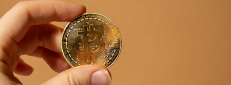 Female hands holding bitcoin gold coin. Bitcoin mining trading concept. BTC golden money spinning...