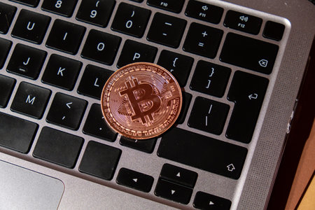 Bitcoin gold coin on keyboard of laptop Mining trading concept. BTC golden money. Worldwide virtual...