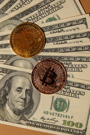 Bitcoin gold coin on bills of 100 dollars American currency. Bitcoin mining trading concept. BTC golden money. Worldwide virtual internet Cryptocurrency or crypto digital payment system. Digital coin money farm in digital cyberspaceの写真素材