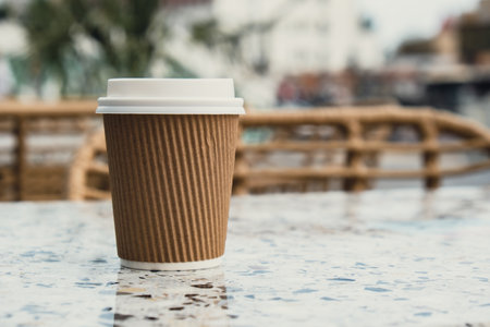 Eco recycling paper cup with coffee or tea on craft paper on table in beach cafe. Take away coffee to go. Copy space for text. Disposableの写真素材