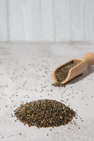 Heap of Chia seeds with wooden spoon. Healthy superfood rich in Omega 3 fatty acids. Dry healthy natural ingredient. Chia grains are fallingの写真素材