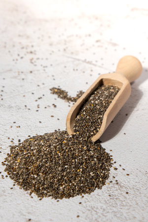 Heap of Chia seeds with wooden spoon. Healthy superfood rich in Omega 3 fatty acids. Dry healthy natural ingredient. Chia grains are fallingの写真素材