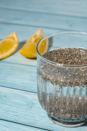 Preparing superfood water drink rich in Omega 3 fatty acids. Pouring coconut water. Adding soaked chia seeds and lemon detox Breakfast. Clean eating, weight loss, dieting food concept Vegetarianの写真素材