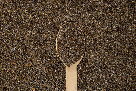 Chia seeds in wooden spoon. Healthy superfood rich in Omega 3 fatty acids. Dry healthy natural ingredient. Chia grains are fallingの写真素材