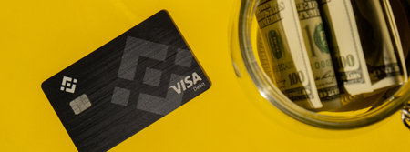 Gdansk Poland - 20 June 2022: Black Binance Coin Card with dollars. Banner Visa debit card BNB,...
