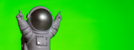 Plastic toy astronaut on green chroma key background Template Mock up Copy space. Concept of out of earth travel, private spaceman commercial flights missions and Sustainabilityの写真素材