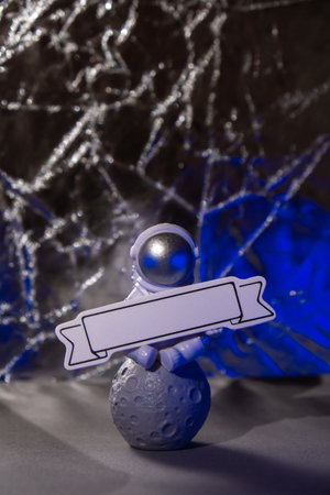 Plastic toy figure astronaut with red and blue light with paper note for your text Copy space. Concept of out of earth travel, private spaceman commercial flights missions and Sustainabilityの写真素材