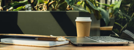 Mock up of modern laptop at table in co-working space. Remote Freelancers place of work. Study and...