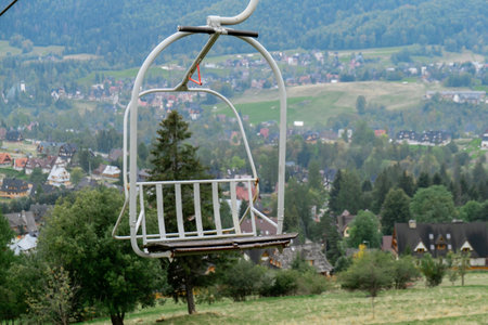 Ski Lift snowy mountain autumn forest with chair lift At The Ski Resort in Zakopane Poland. Holidays...