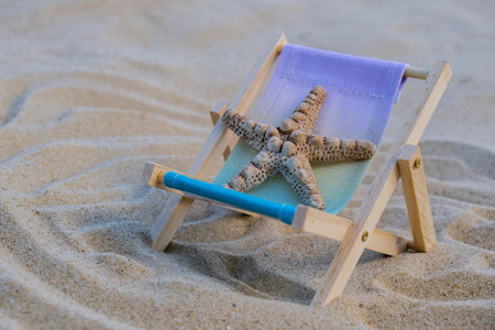 Sunny holidays on the beach with sand beach accessories with sea shells and sea star. Sun lounger...