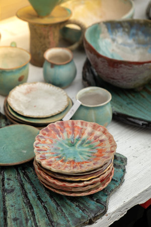 Gdansk, Poland - 9 August 2022 Polish culture - showcase with folk products on the street market. Hand painted mugs. Dominics Fair in Gdansk Colorful collection of mugs on the counter of gift shop in Gdansk. Souvenirのeditorial素材